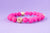 Pulsera piedra volcánica rosa fucsia con bolas doradas