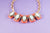 Collar corto eslabones dorados con 5 rectangulos melon y lila