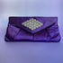 Bolsa Clutch Morada, tapa triangular con flores plateadas brillosas en forma de rombo